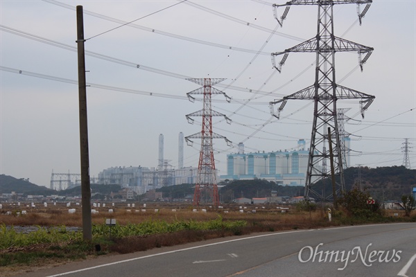 765Kv 송전철탑 사이로 보이는 충남 당진에 위치한 화력발전소