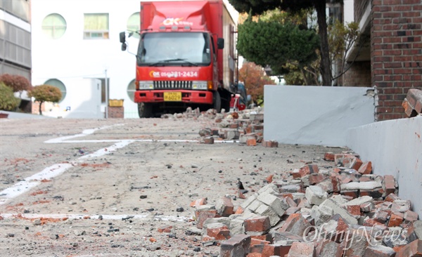 지진 피해로 사용 불가 판정이 내려진 포항시 북구 대동빌라 주민들의 집단 이주가 22일 시작됐다. 빌라 외벽에서 떨어진 벽돌이 여전히 곳곳에 쌓여있다. 