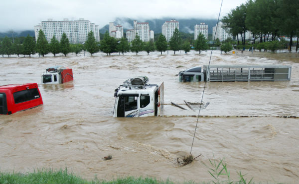 지난 7월 16일 내린 집중호우에 충북 증평군 증평읍 보강천 하상주차장에 주차된 차량들이 물에 잠겨 있다.(사진 뉴시스)