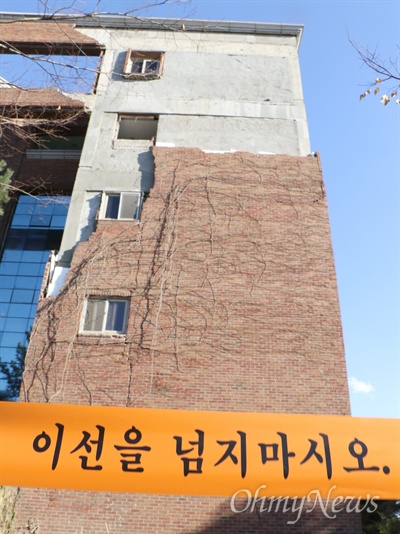 지진으로 외부 벽돌이 떨어져 나간 포항시 흥해읍 한동대학교 건물에서 23일 출입 통제선이 설치되어 있다. 