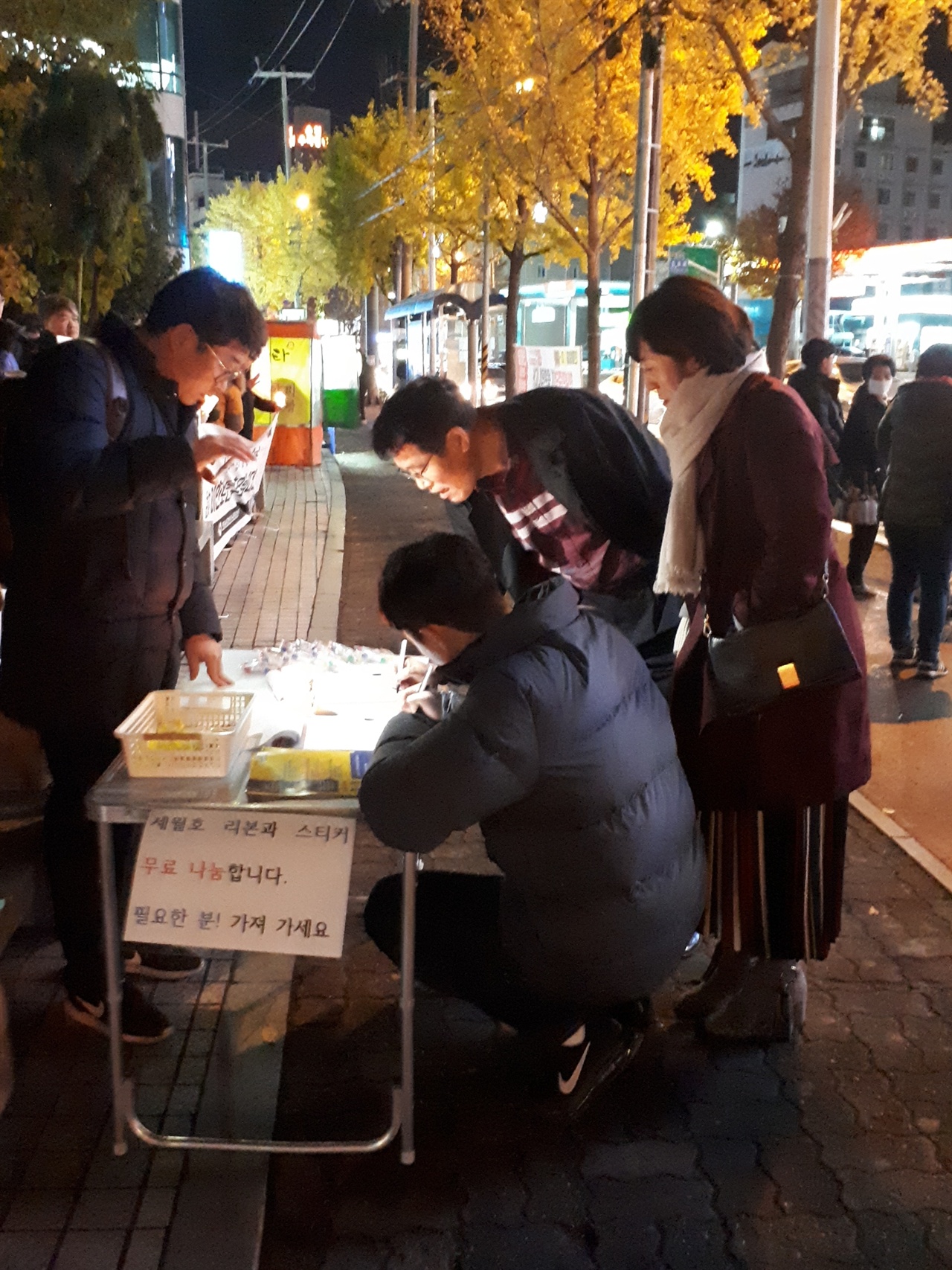 서명하는 가족 현장실습 도중에 사고로 사망한 고 이민호 군을 위한 추모집회에서 어느 가족이 현장실습 폐지 청원서에 서명을 하고 있다. 