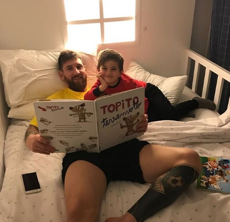  리오넬 메시가 첫째 아들 티아고에게 동화책을 읽어주고 있는 모습