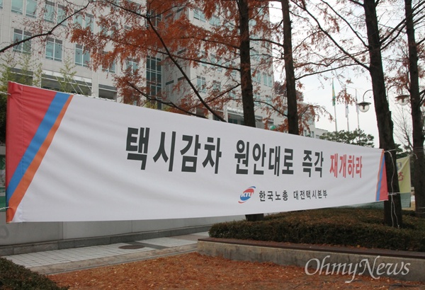 대전지역 일반택시 노동자들은 "당초 계획대로 택시감차를 실시하라"며 대전시청 인근에 플래카드를 내걸고 항의집회를 이어가고 있다.