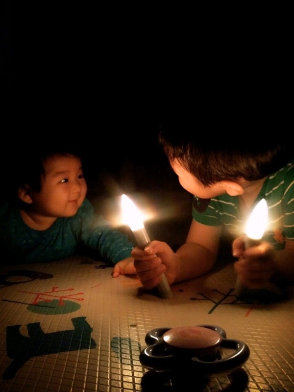 집에서 LED촛불을 들고 놀고 있는 정치하는엄마들 조성실 공동대표의 자녀들