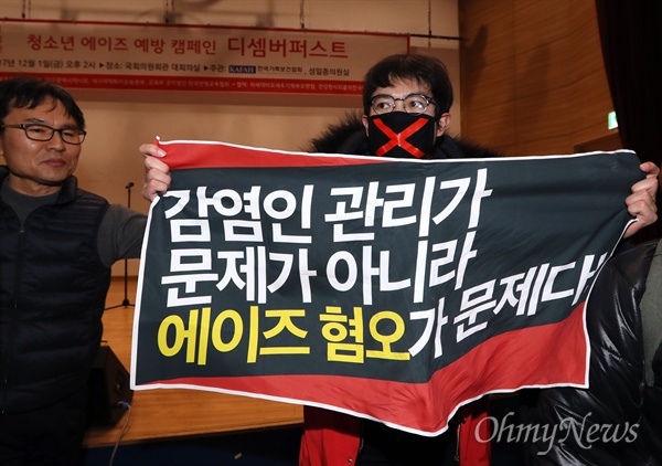 2017 세계 에이즈의 날 기념행사로 2017년 12월 1일 오후 서울 여의도 국회 의원회관 대회의실에서 열린 '디셈버퍼스트(December First)' 행사에서 HIV/AIDS 인권활동가 네트워크 활동가들이 에이즈 혐오를 확산시키는 데 대해 항의하며 현수막을 펼치고 있다. 