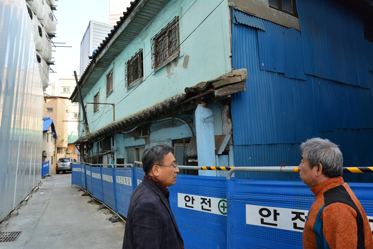 설기훈씨와 김용수씨 목조건물 앞에서 건물 복원감정에 대한 대처방안을 논의중이다. 