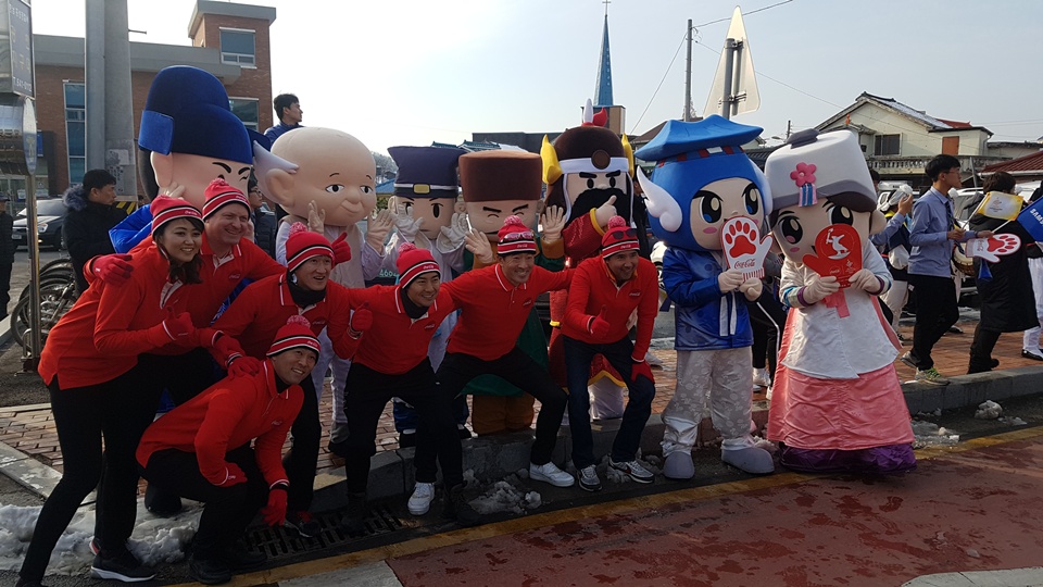 6일 오후 2018평창동계올림픽 성화봉송행사가 열리는 홍성군 광천읍을 찾은 외국인들이 홍성이 배출한 역사인물 캐릭터 앞에서 2018평창동계올림픽을 축하하고 있다.