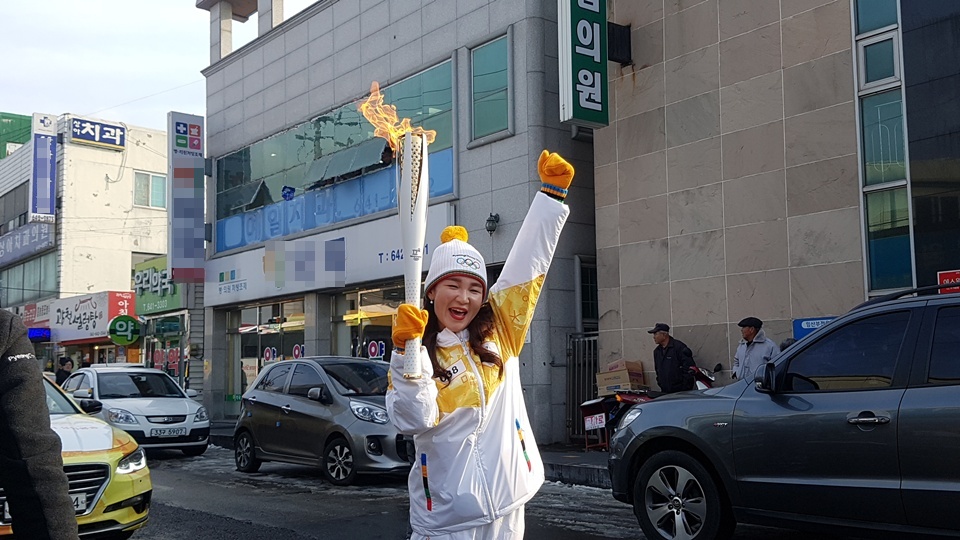 6일 오후 홍성군 광천읍에서 열린 2018평창동계올림픽 성화봉송행사에서 한 참가자가 성화를 들고 환호하고 있다.