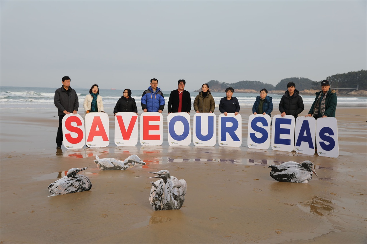다시 깨끗해진 만리포 해변에서 '우리 바다를 구하자'고 외치는 환경운동연합 회원들