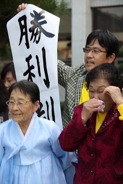 광주지방법원 승소 판결 후 법정을 나오면서 하세가와 가즈히로 변호사가 승소를 알리는 손글씨를 펼쳐 보이며 기뻐하는 모습.(2013년 11월 1일)