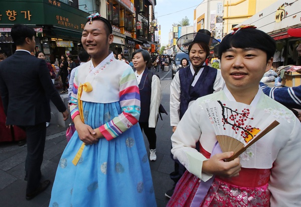 '남자는 왜 치마 한복을 입으면 안 되죠?' 퀴어 활동가 김우주 씨(왼쪽)를 비롯한 성적 소수자와 지지자들이 2016년 10월 13일 오후 서울 종로구 인사동에서 남자는 치마 한복, 여자는 바지 한복을 입고서 퍼레이드를 하고 있다. 이날 퍼레이드는 한복을 입으면 고궁에 무료 입장할 수 있도록 한 문화재청이 남자는 바지 한복을, 여자는 치마 한복을 입어야 한다는 규정을 둔 것에 항의의 뜻을 전하기 위해 열렸다. 
