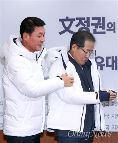 오늘은 빨간색 아닙니다 자유한국당 홍준표 대표가 11일 오전 서울 여의도 당사에서 2018 평창 동계올림픽-패럴림픽 대회 입장권 구매 협약식에 참석해 황영철(강원 홍천군철원군화천군양구군인제군) 의원이 입혀주는 기념 패딩점퍼를 착용하고 있다. 