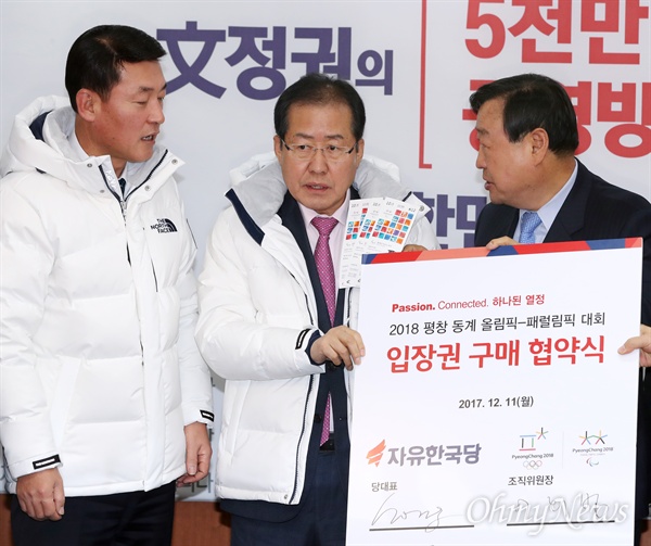 홍준표도 구매한 평창동계올림픽 입장권 자유한국당 홍준표 대표가 11일 오전 서울 여의도 당사에서 열린 2018 평창 동계올림픽-패럴림픽 대회 입장권 구매 협약식에 참석해 구매한 입장권을 들어보이고 있다. 왼쪽은 강원 홍천군철원군화천군양구군인제군이 지역구인 황영철 의원. 