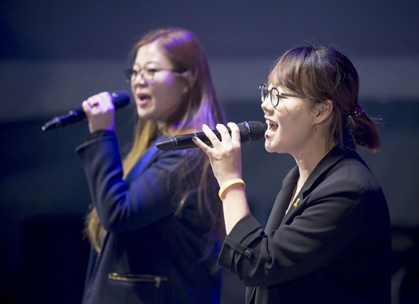  노래패 우리나라 가수 이혜진(오른쪽), 가수 달로와. 2017년 10월 28일 서울 광화문 광장서 열린 촛불집회 1주년 대회, '촛불은 계속된다'에서 노래패 우리나라가 공연하고 있다. 