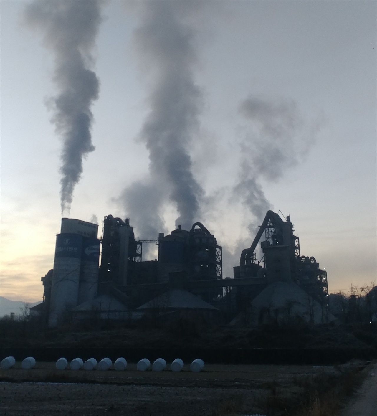 석양 위로 단양군 매포읍 시멘트 공장에서 연기가 뿜어져 나오고 있다