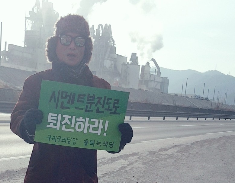 나순결 충북녹색당 공동운영위원장이 단양군 매포읍의 한 시멘트 공장 인근 도로에서 1인 시위를 하고 있다.