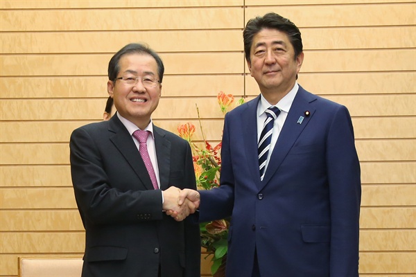 홍준표 자유한국당 대표와 아베 신조 일본 총리. 사진은 지난해 12월 14일 서로 만나 악수하고 있는 모습. 