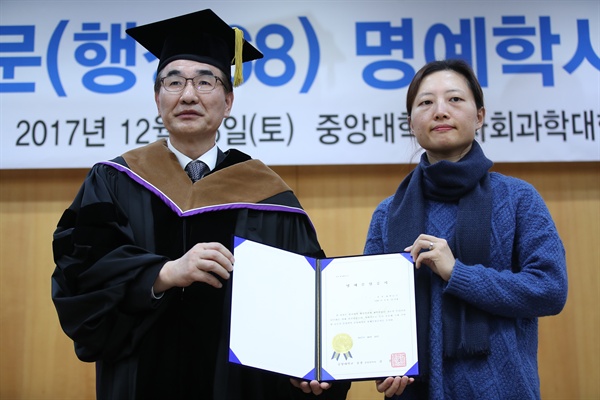  16일 오후 서울 동작구 중앙대학교에서 열린 고 백남기 동문 명예학사학위 수여식에서 딸 백도라지씨가 김창수 총장으로부터 백남기 씨의 명예졸업증서를 받고 있다. 