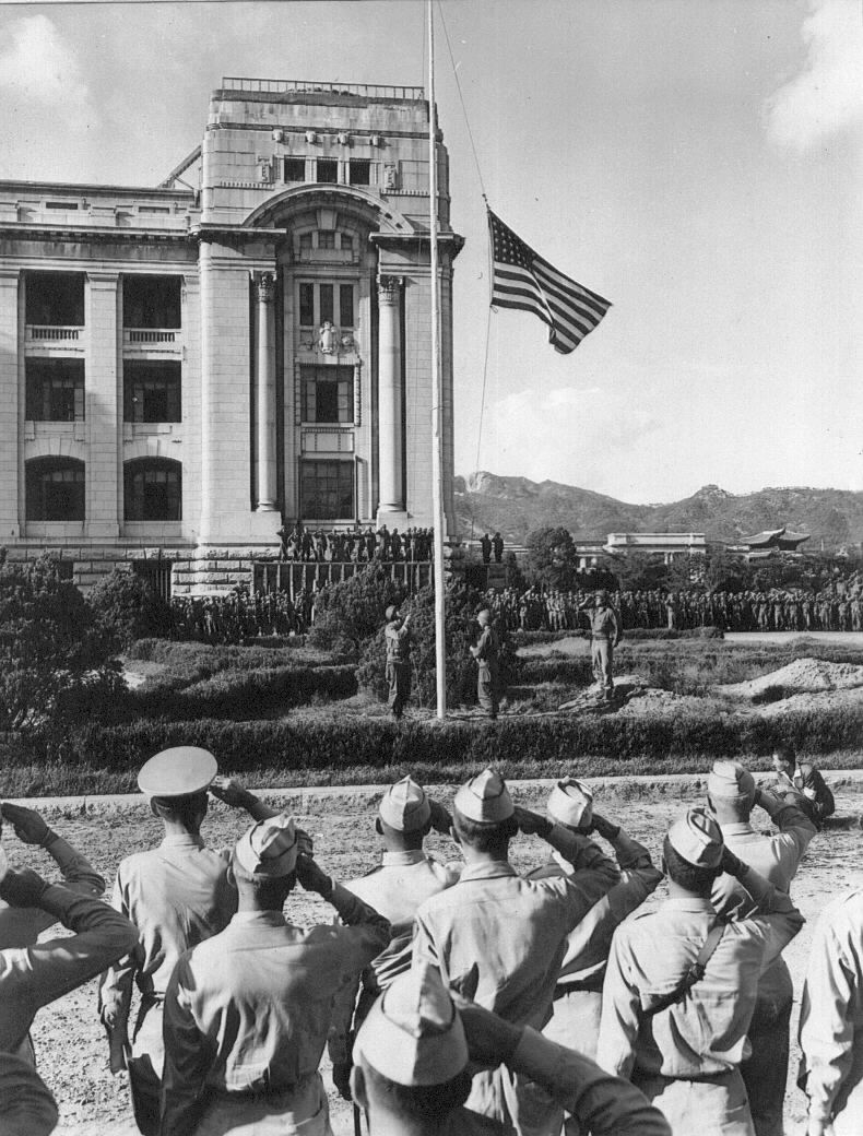 1945년 9월 9일, 미군의 경례를 받으면서 조선총독부 광장 국기게양대에 일장기 대신 성조기가 게양되고 있는 모습. 