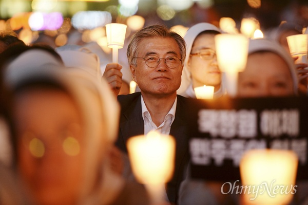 지난 2013년 9월 23일 서울광장에서 열린 '국정원 해체 민주주의 회복 시국미사'에 당시 문재인 민주당 의원이 참석해 촛불을 들고 무대를 바라보고 있다.