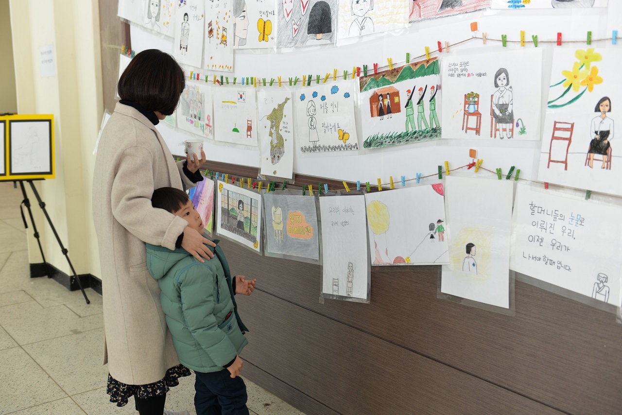 순창향토회관에서 평화의소녀상 기념식의 일부로 진행된 순창중앙초등학교 학생들의 평화의소녀상 작품전을 어머니와 아들로 보이는 두사람이 감상하고 있다. 