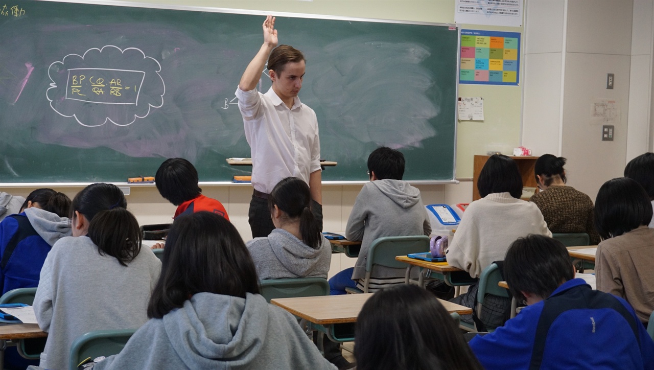 일본 삿포로 가이세이중등학교에서 IB 교육과정으로 수학을 지도하는 토마스 베르쇼 교사가 힉생들에게 질문을 한 뒤 답변해 보라면서 손을 들어보이고 있다.