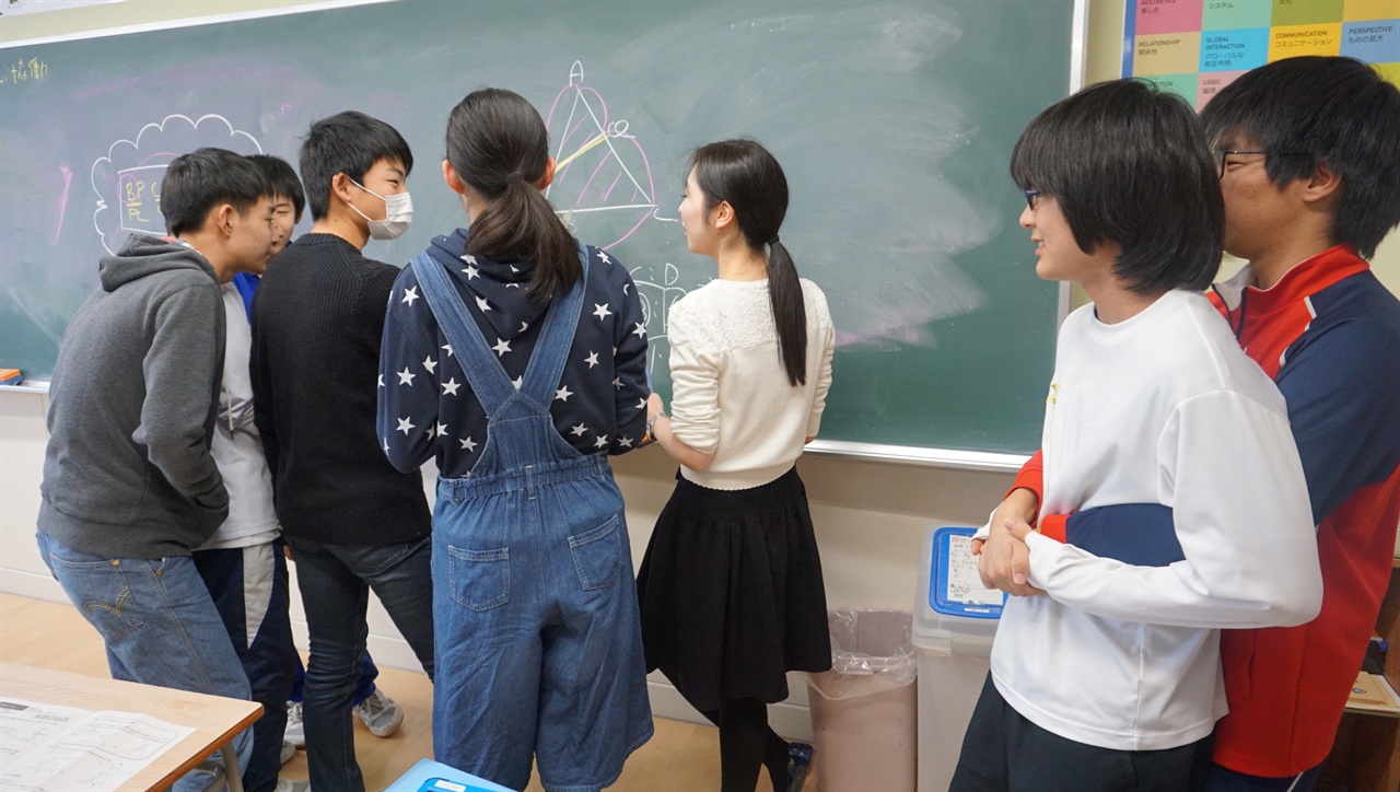 수학 수업을 마친 뒤 학생들이 칠판 앞에 있던 교사에게 가서 질문하는 장면.
