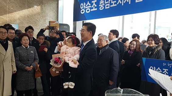 양승조 의원이 출마 기자회견을 열기전 어린 아이를 안고 기념 촬영을 하고 있다. 