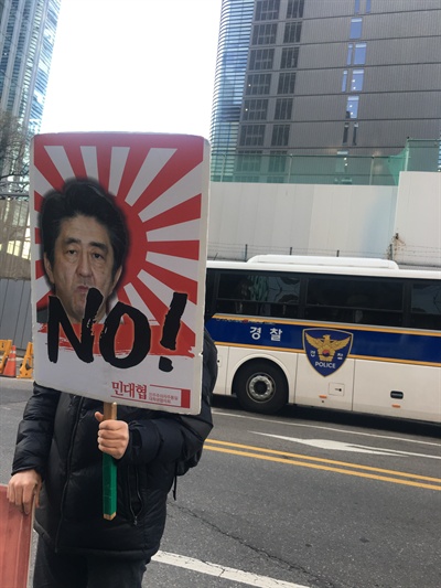 6일 한 집회 참가자가 전범기에 그려진 아베 일본 총리 얼굴에 NO! 라고 쓰인 팻말을 들고 있다. 