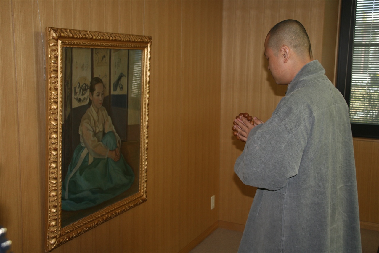 문화재제자리찾기 혜문 대표가 일본 니가타 마쓰모토 시립미술관에 소장돼 있는 홍련화를 보고 염불을 하고 있다. 홍련화는 명월이로 추정되는 그림이다. 
