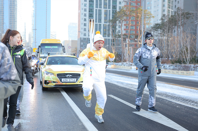  2012 런던올림픽 배드민턴 남자복식 동메달리스트 정재성 감독이 10일 인천에서 평창 동계올림픽 성화봉송을 하고 있다.
