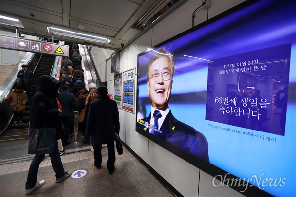 시민들이 11일 서울 5호선 광화문역에 걸린 문재인 대통령 생일 축하 광고를 지나치고 있다. 이 광고는 "문재인 대통령을 응원하는 평범한 여성들"이라고 밝힌 지지자들이 마련한 것이다. 