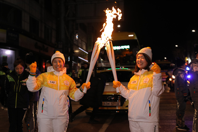  골프 여제 박세리(왼쪽)가 지난 10일 인천 시내에서 2018 평창 동계올림픽 성화봉송에 참여해, 2006 토리노올림픽 쇼트트랙 금메달리스트 변천사(오른쪽)에게 주자를 넘겨받고 있다. 