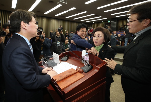 국민의당 안철수 대표가 12일 오후 국회에서 열린 당무위원회의에서 바른정당과의 통합에 반대하는 장정숙 의원의 항의를 받고 있다.