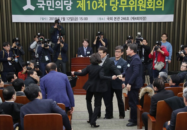 국민의당 안철수 대표가 12일 오전 국회에서 열린 당무위원회의에서 통합 반대파와 찬성파 위원들의 몸싸움 와중에도 발언을 이어가고 있다.