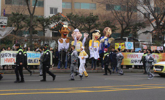 국제평화단체 HWPL의 회원들이 성화봉송 주자가 지나가자 환호하고 있다.