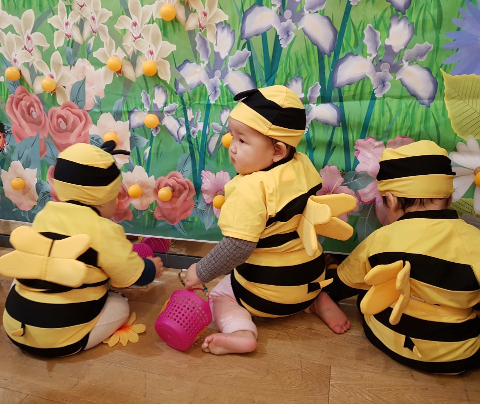 11개월 된 둘째 아이가 문화센터에서 꿀벌 옷을 입고 꽃에 있는 꿀(탁구공)을 따고 있다.