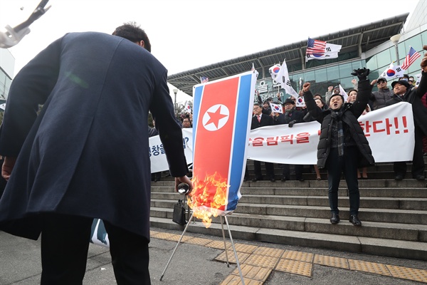  22일 오전 서울역 광장에서 조원진 대한애국당 대표와 당원들이 '기자회견 평양올림픽? 평창올림픽 반대 기자회견'에서 한반도기, 인공기를 불태우고 있다.