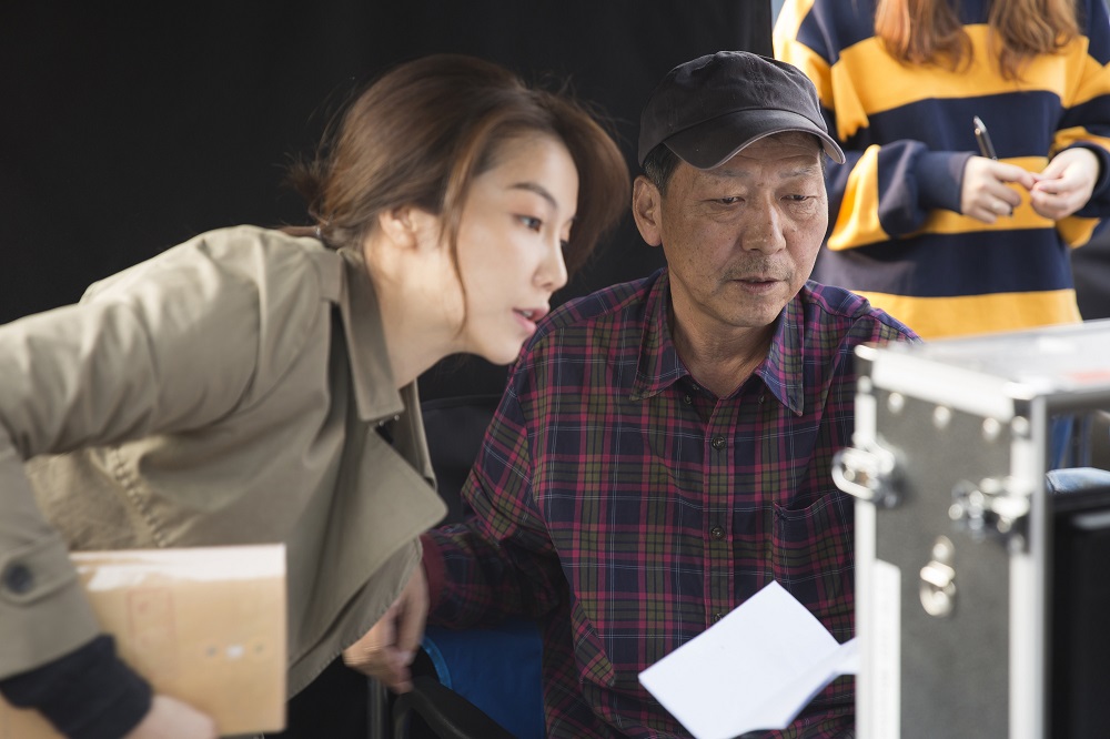  영화 <1급 기밀>을 연출한 고 홍기선 감독이 김옥빈 배우와 함께 촬영장면을 확인하고 있다.