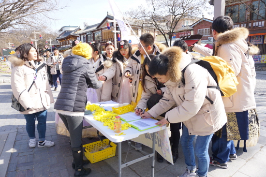 세월호 서명운동에 함께하는 전주 한옥마을 관광객들에게 오봉숙씨가 리본을 나눠주고 있다.
