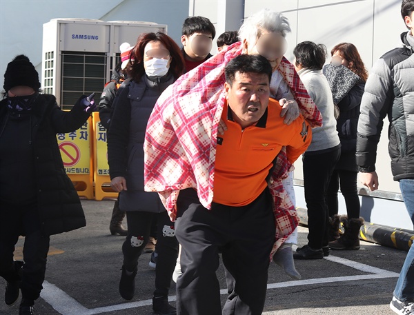 밀양 세종병원 환자 긴급 대피 26일 오전 7시 30분께 경남 밀양시 가곡동 세종병원에서 불이나 소방대원이 환자를 업고 긴급히 대피시키고 있다.