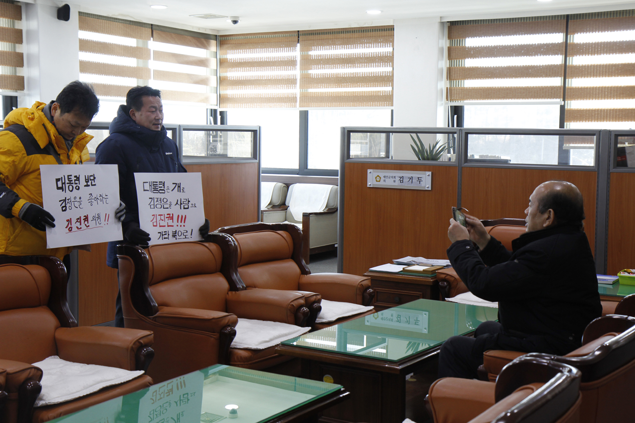 대화를 하자며 문팬카페회원들을 태안군의원실로 데리고 들어온 김진권 의원이 대화를 하면서 시위자들을 찍고 있다.