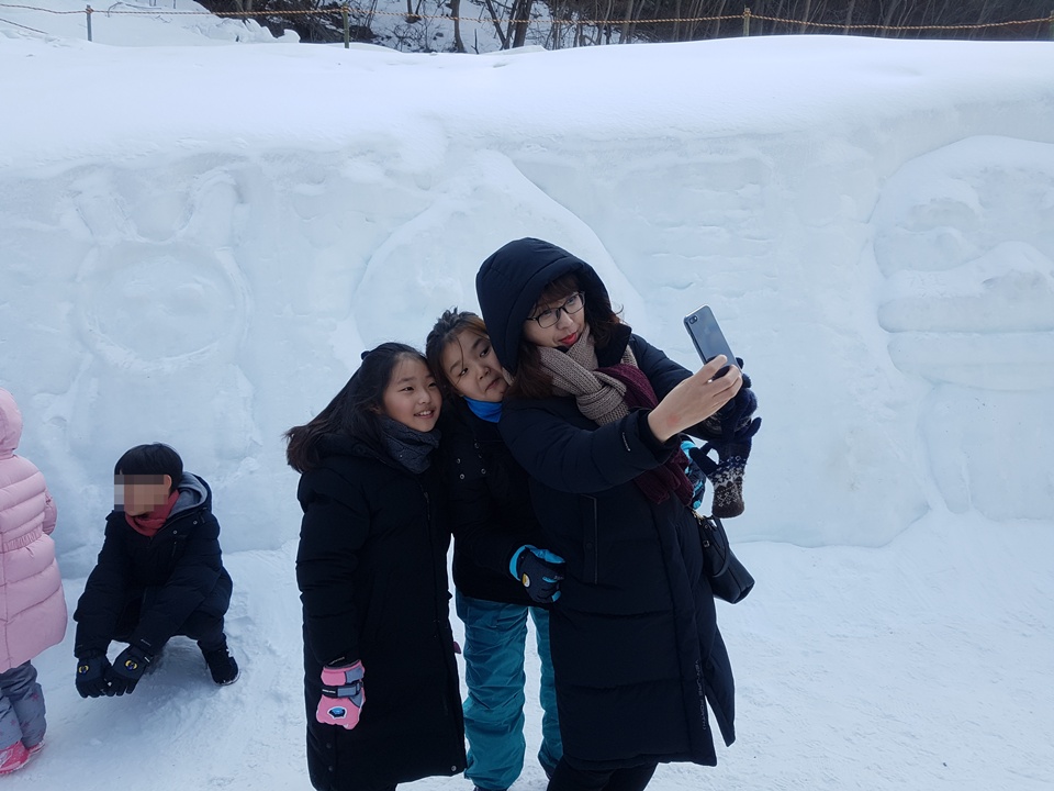 '얼음분수축제'를 찾은 관광객들이 얼음분수를 배경으로 아이들과 사진을 찍고 있다.