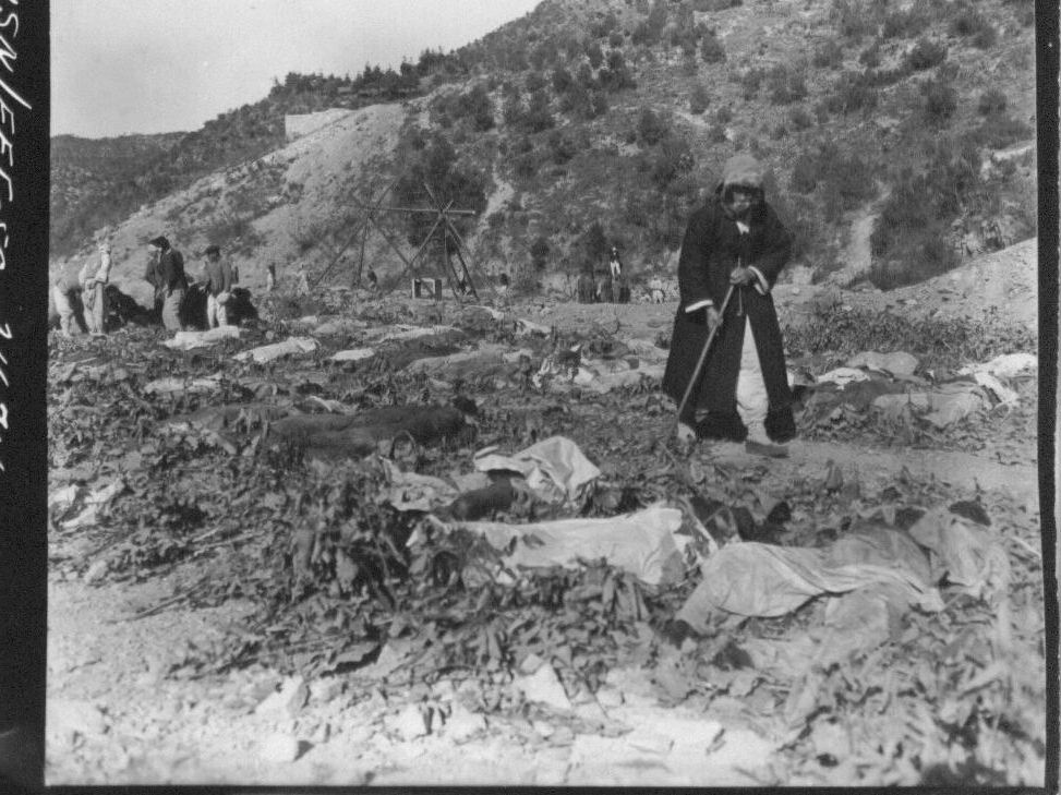1950. 11. 14. 함흥. 어느 아버지가 덕산 광산 인근 밭에 늘려져 있는 400여 구의 학살 시신 가운데서 아들을 찾고 있다.
