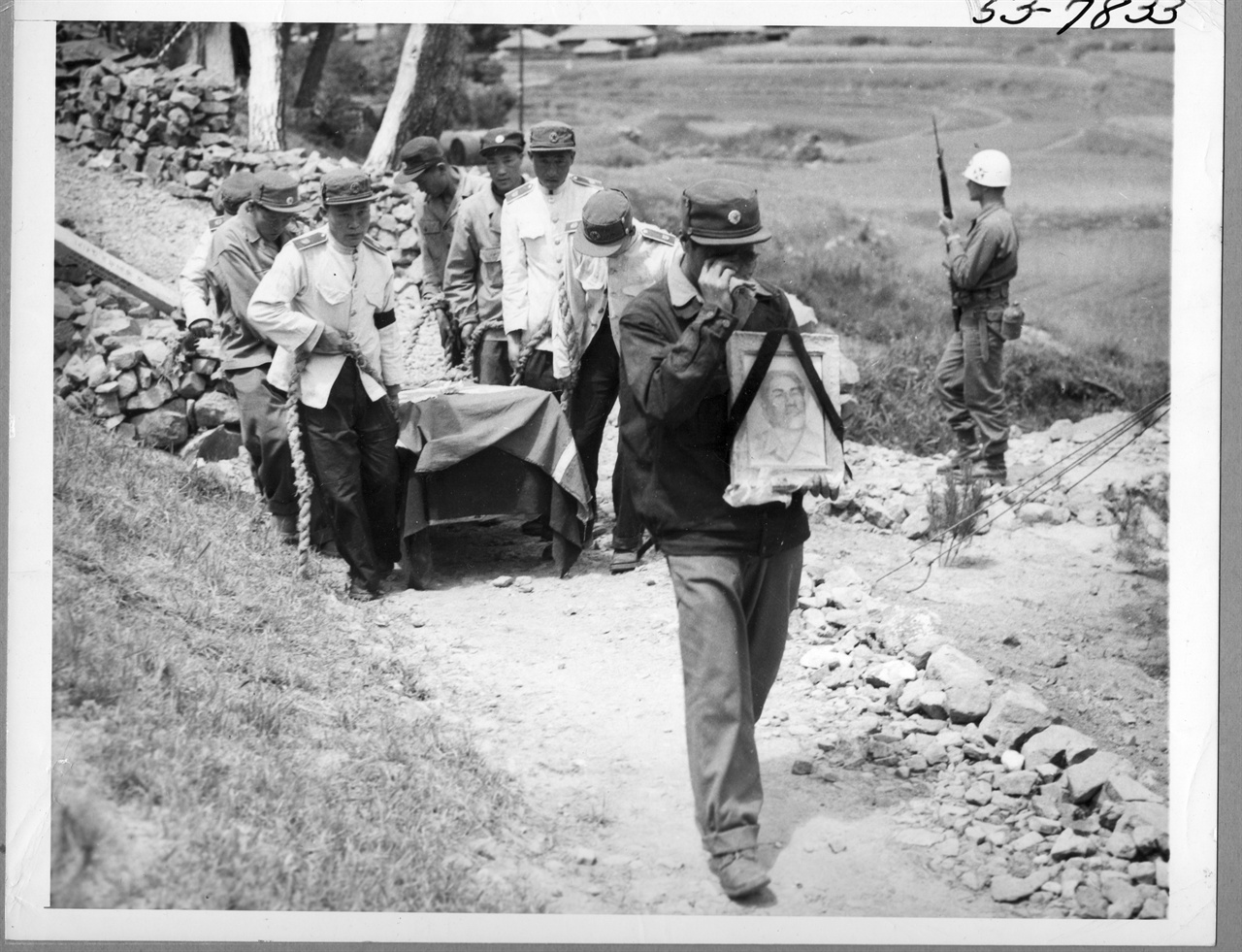  1952. 6. 6. 거제도, 포로수용소 안에서 시위를 주동한 포로가 죽자 동료 인민군들이 영정을 앞세우고 시신을 묻으러 포로수용소 바깥 무덤으로 운구하고 있다. 