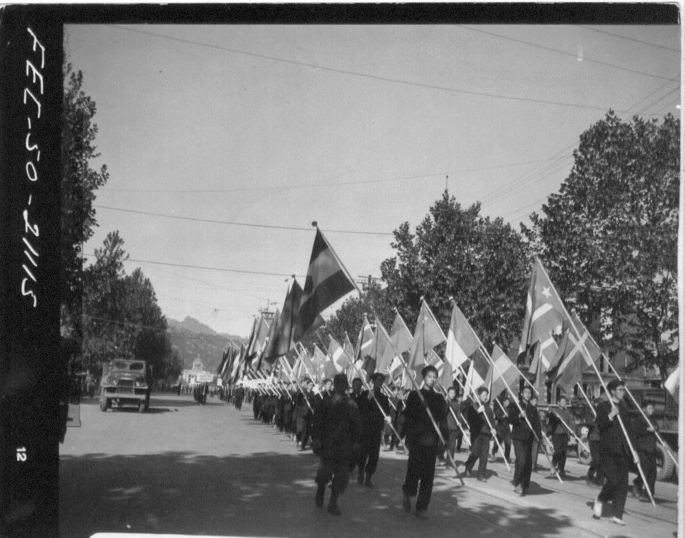 1950. 10. 27. 서울. 시민과 학생들이 유엔 참전국 국기를 들고 광화문에서 평화 행진을 하고 있다.