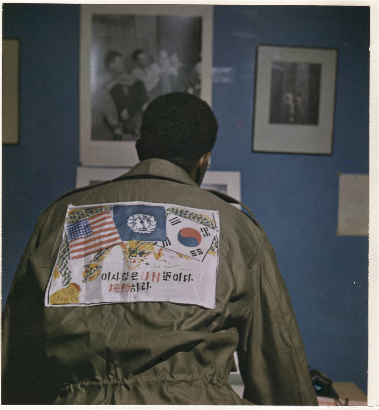 1950. 11. 20. 한 유엔군이 등 뒤에 “이 사람은 유엔군이다. 원조하라”라는 문안을 새긴 옷을 입고 있다. 