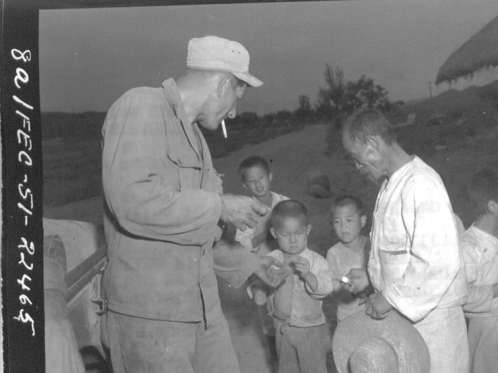 1951. 6. 27. 한 유엔군이 어린이들에게 초콜릿을 나눠주고 있다.
