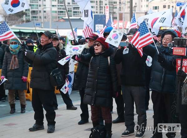 보수단체 "평창올림픽 거부한다" 현송월 삼지연관현악단장이 이끄는 북측 예술단 첫 공연이 8일 오후 강원도 강릉 아트센터에서 열릴 예정인 가운데, 보수단체 회원들이 공연장 인근에 모여 태극기와 성조기를 흔들며 시위를 벌이고 있다.