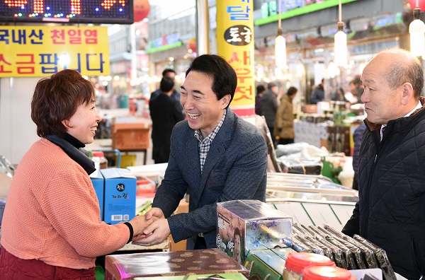 광천장을 찾은 박수현 전 전와대 대변인이 상인과 반갑게 인사를 나누고 있다.